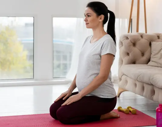 pregnant woman sitting on a yoga mat